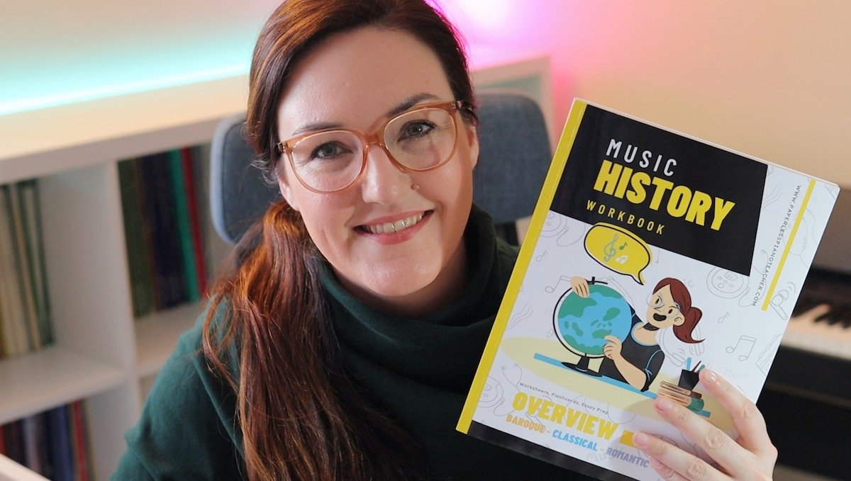Ms. Kristin holding a Music History workbook in her teaching studio